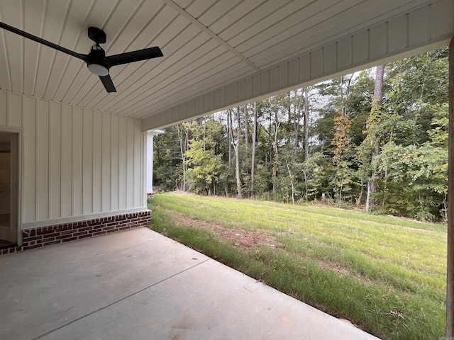 view of patio / terrace featuring a forest view and a ceiling fan