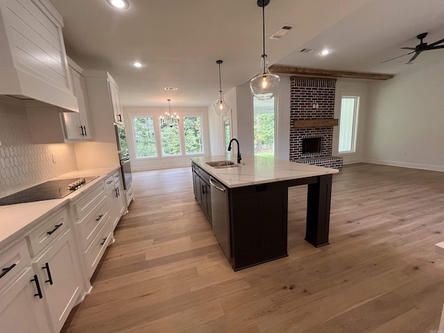 kitchen featuring a sink, visible vents, open floor plan, appliances with stainless steel finishes, and range hood