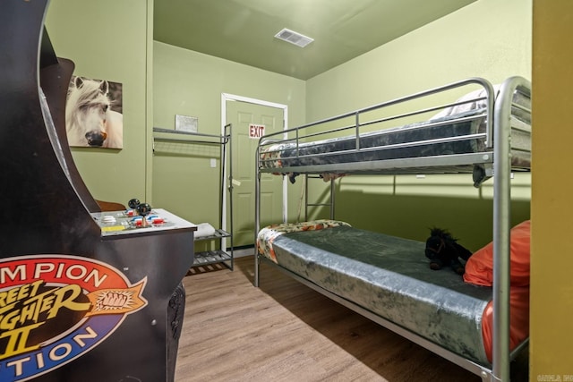 bedroom featuring wood finished floors and visible vents