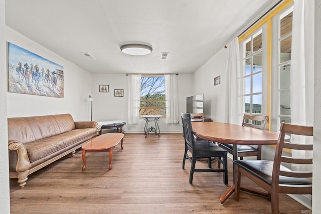 dining room with baseboards, visible vents, and wood finished floors