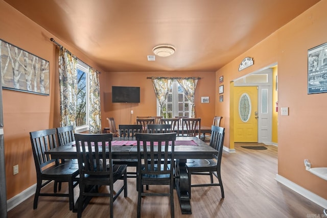 dining room featuring a wealth of natural light, baseboards, and wood finished floors