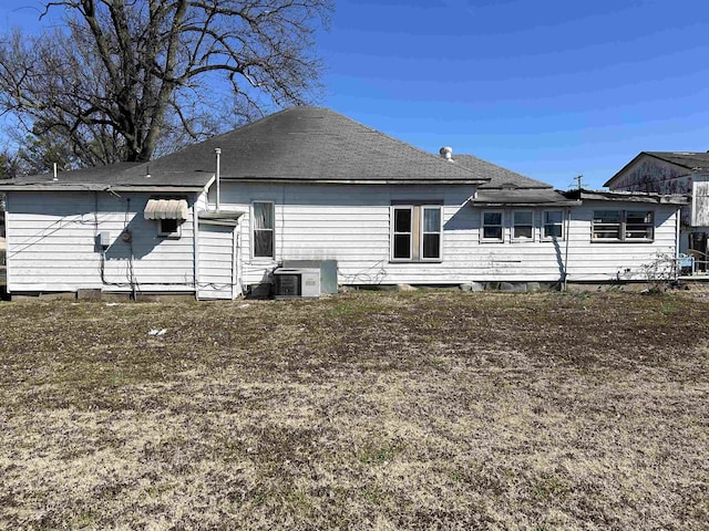 rear view of property with roof with shingles