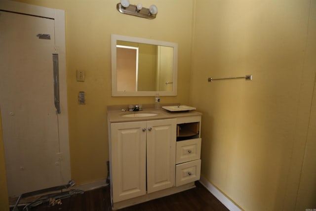 bathroom with wood finished floors, vanity, and baseboards