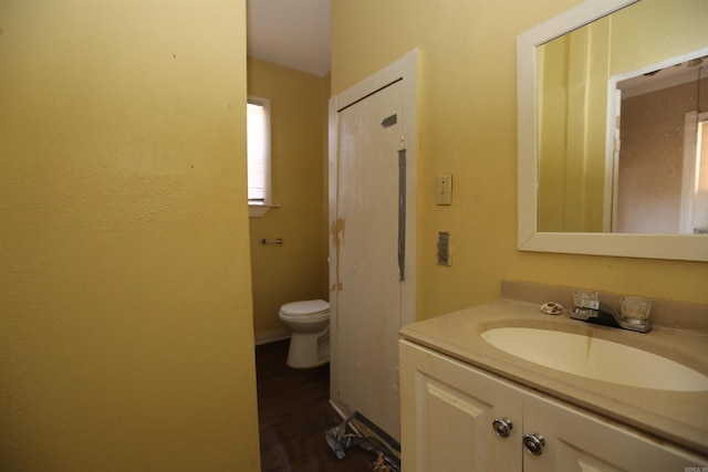 bathroom featuring vanity, toilet, and wood finished floors