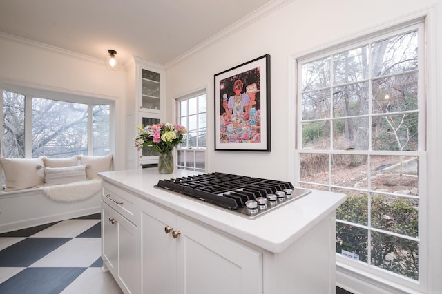 kitchen with white cabinets, stainless steel gas cooktop, ornamental molding, and tile patterned floors