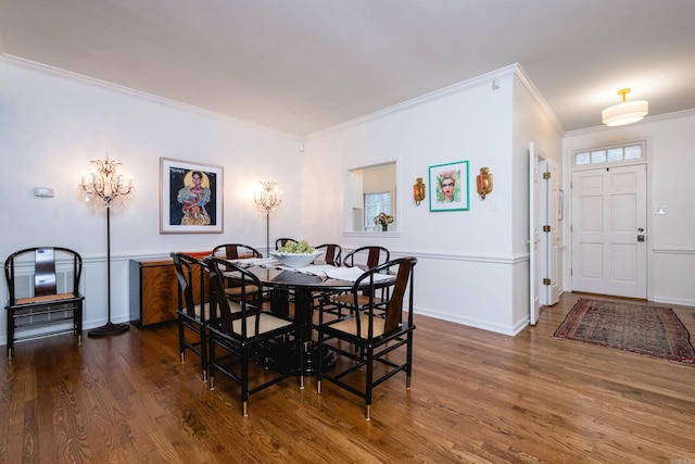 dining space featuring crown molding, baseboards, and wood finished floors