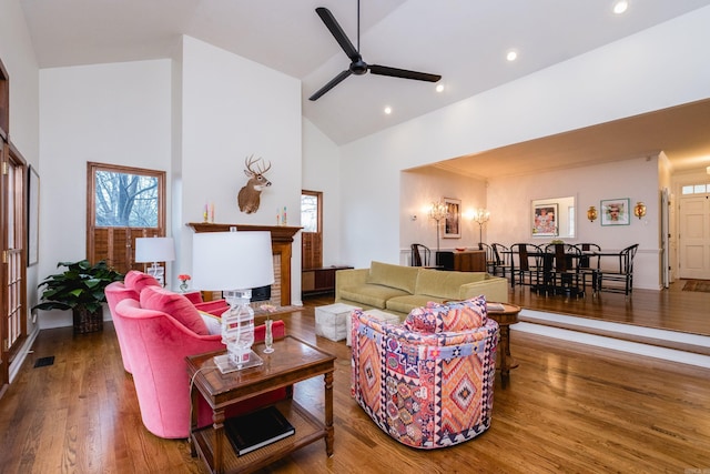 living area with a fireplace, recessed lighting, ceiling fan, high vaulted ceiling, and hardwood / wood-style floors