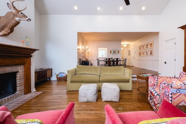 living area featuring a brick fireplace, wood finished floors, and recessed lighting