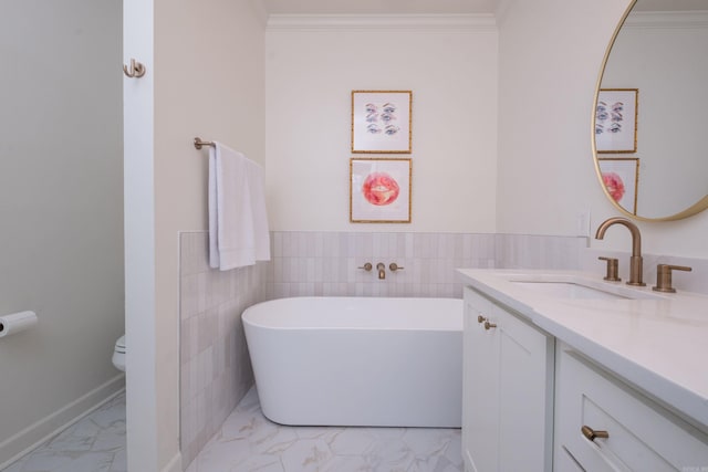 bathroom with marble finish floor, toilet, ornamental molding, vanity, and a freestanding tub