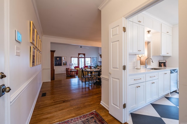 interior space featuring ornamental molding, light countertops, a sink, and stainless steel dishwasher