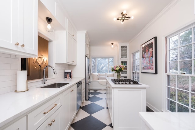 kitchen featuring light floors, stainless steel appliances, ornamental molding, a sink, and a chandelier