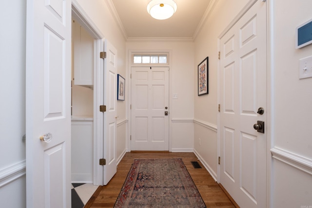 entryway featuring crown molding, baseboards, and wood finished floors