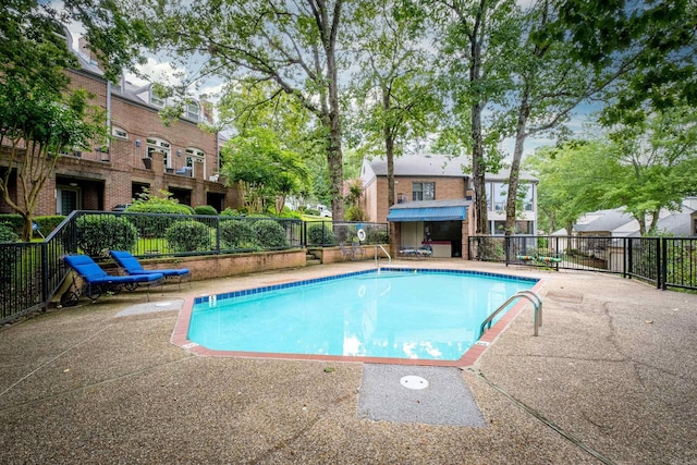 community pool with a patio area and fence