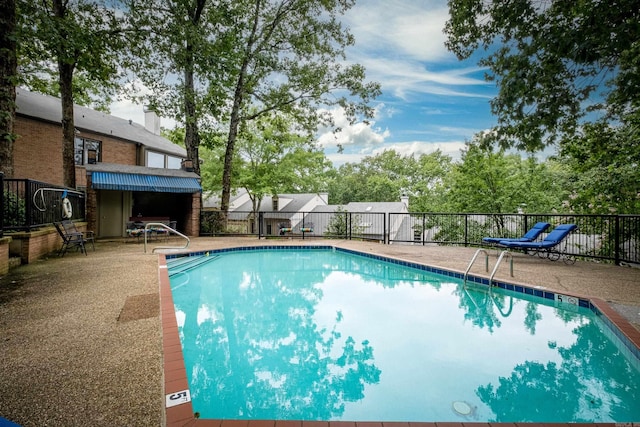 pool with fence and a patio