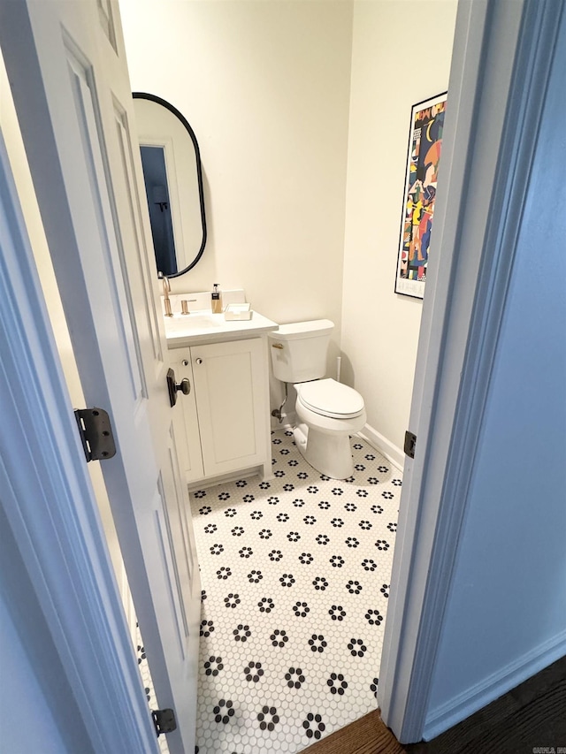 bathroom featuring vanity, toilet, and baseboards