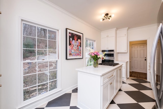 kitchen featuring crown molding, light floors, stainless steel appliances, light countertops, and white cabinets