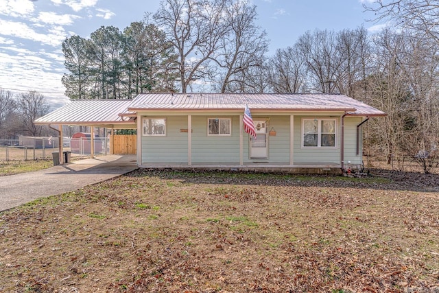 view of front of home with a porch, an attached carport, metal roof, and fence