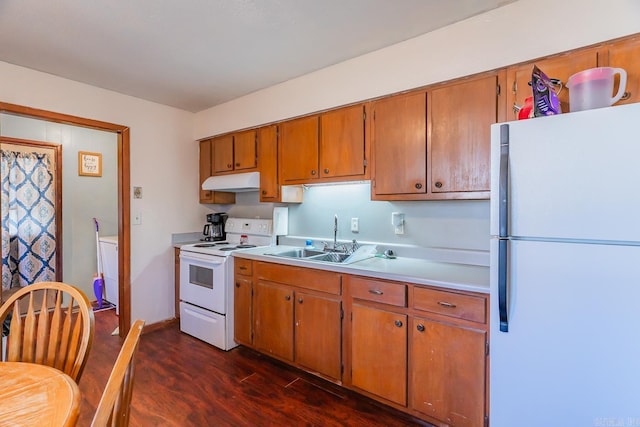 kitchen featuring dark wood-style floors, light countertops, a sink, white appliances, and under cabinet range hood