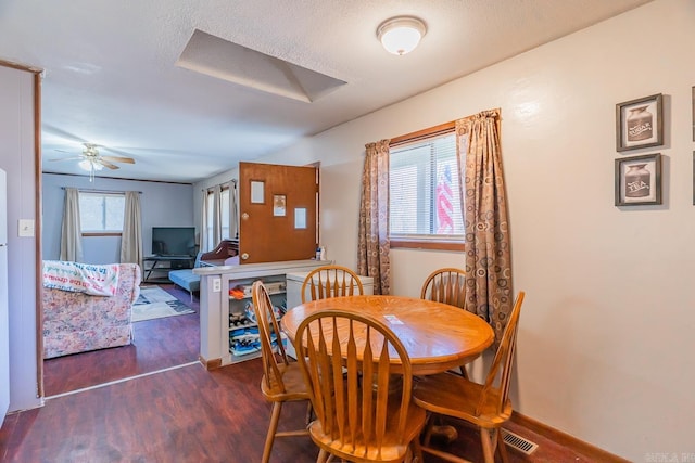 dining space with visible vents, a ceiling fan, attic access, a textured ceiling, and wood finished floors