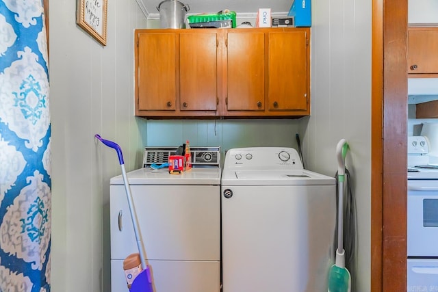 laundry area with cabinet space, separate washer and dryer, and crown molding