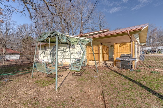 exterior space with metal roof and fence