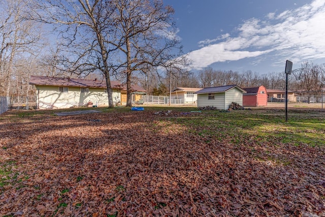 view of yard with fence and an outdoor structure