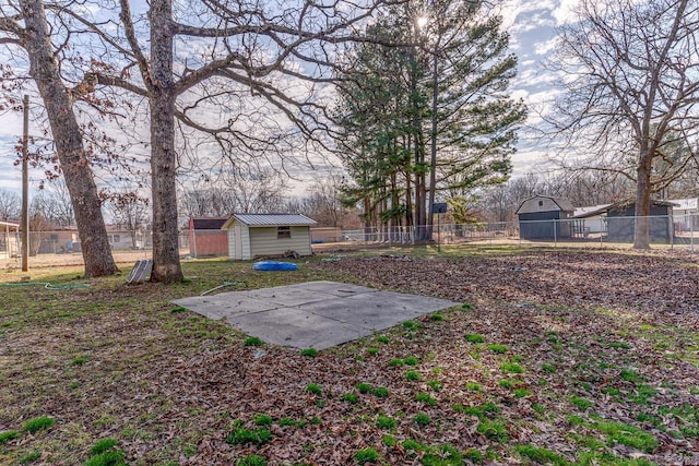 view of yard featuring an outbuilding, a storage shed, and fence