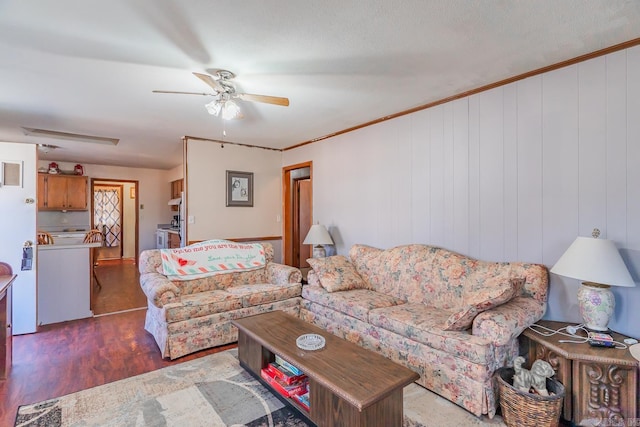 living room with wood finished floors, a ceiling fan, and crown molding