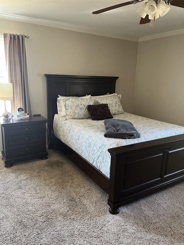 bedroom featuring a textured ceiling, ornamental molding, a ceiling fan, and light colored carpet