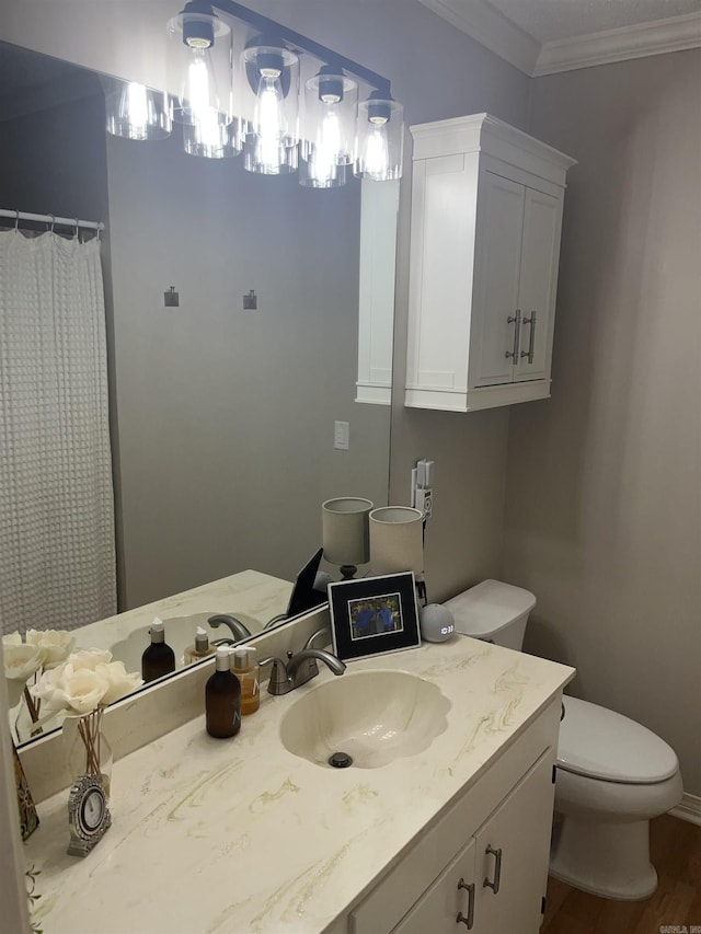 full bath with toilet, wood finished floors, crown molding, and vanity