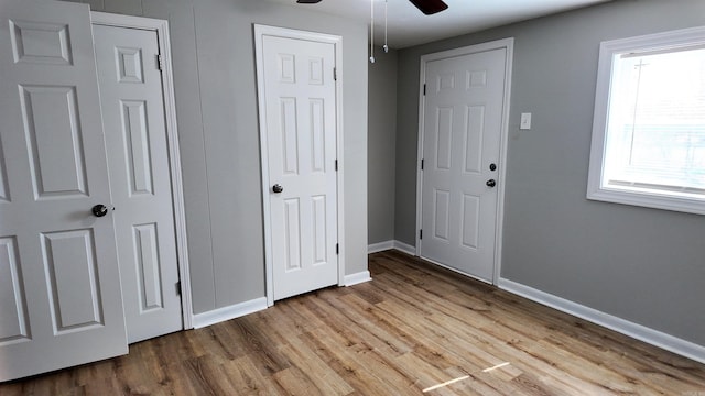 unfurnished bedroom with ceiling fan, baseboards, and wood finished floors