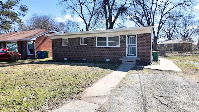 view of front of house with crawl space, brick siding, fence, and a front lawn