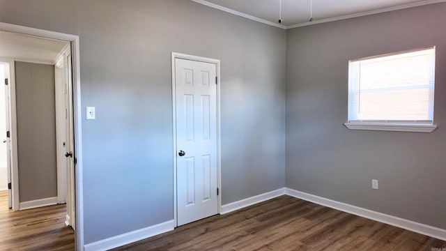 unfurnished bedroom with crown molding, dark wood finished floors, and baseboards