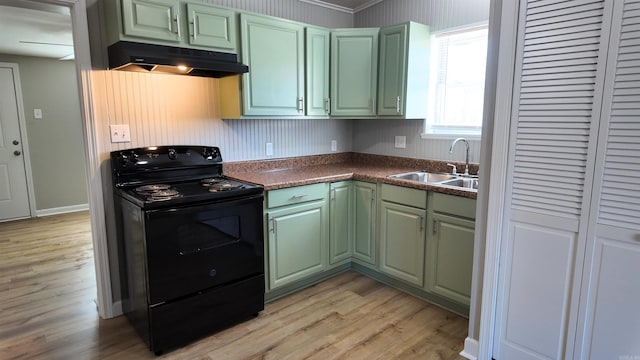 kitchen featuring green cabinets, electric range, a sink, and under cabinet range hood