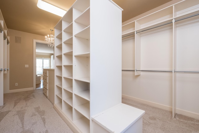 spacious closet with carpet, visible vents, and a notable chandelier