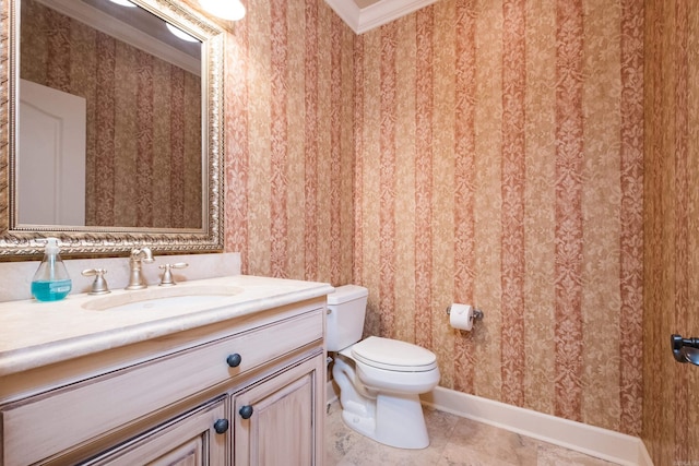 bathroom featuring toilet, vanity, baseboards, wallpapered walls, and crown molding