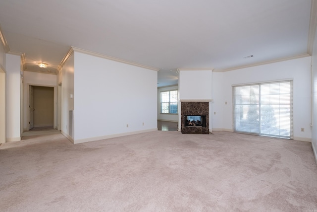 unfurnished living room featuring ornamental molding, a high end fireplace, light carpet, and baseboards