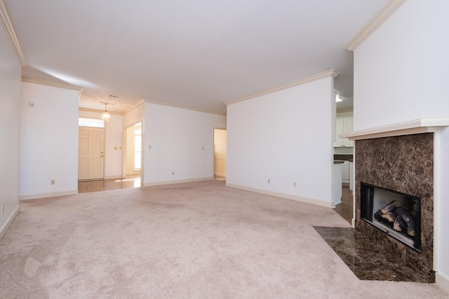 unfurnished living room with carpet floors, a fireplace, baseboards, and crown molding