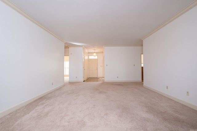 carpeted spare room featuring baseboards and ornamental molding