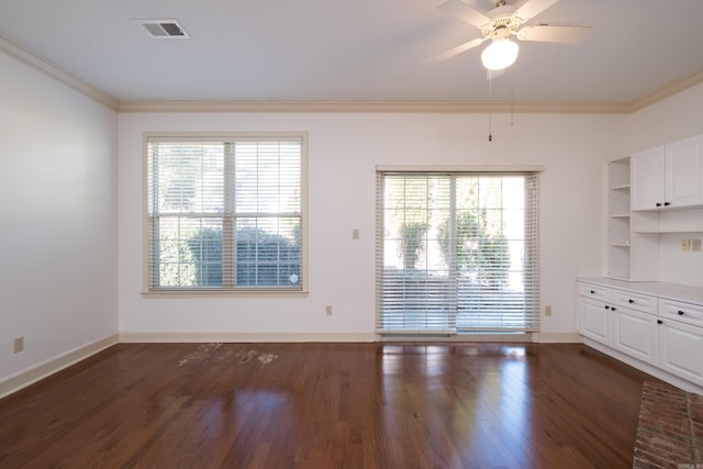 unfurnished dining area with baseboards, visible vents, dark wood finished floors, ceiling fan, and ornamental molding