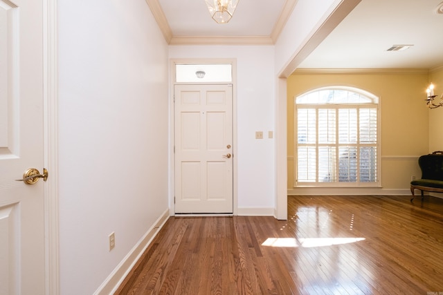 foyer entrance featuring baseboards, visible vents, ornamental molding, and wood finished floors