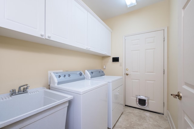 laundry area featuring washing machine and clothes dryer, a sink, and cabinet space