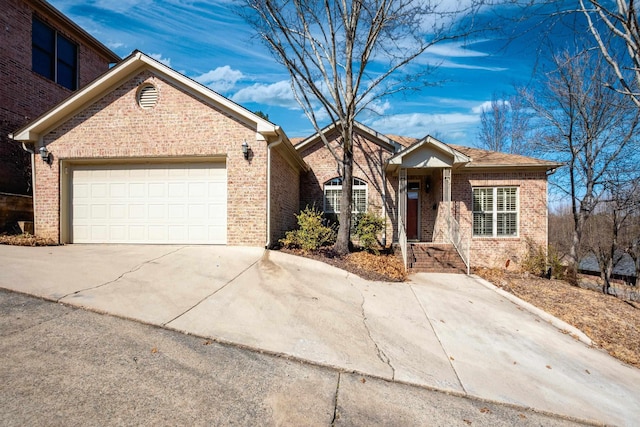 ranch-style house featuring an attached garage, driveway, and brick siding