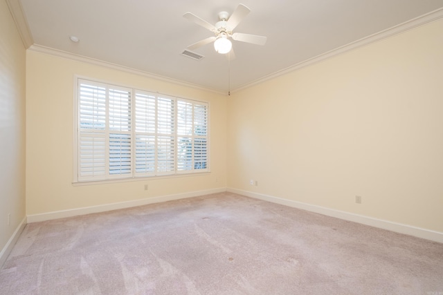 unfurnished room with ceiling fan, light colored carpet, visible vents, baseboards, and ornamental molding