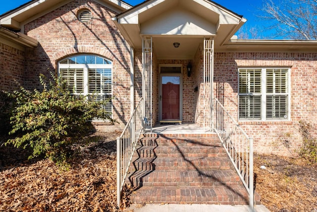 view of exterior entry featuring brick siding