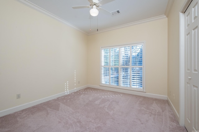 spare room featuring baseboards, carpet, visible vents, and crown molding