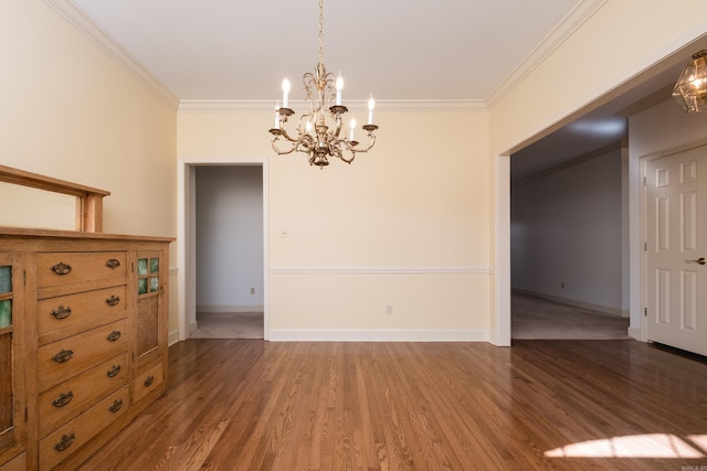 unfurnished dining area with an inviting chandelier, baseboards, ornamental molding, and wood finished floors