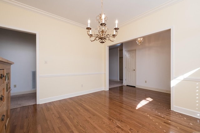 unfurnished room with a chandelier, wood finished floors, and crown molding