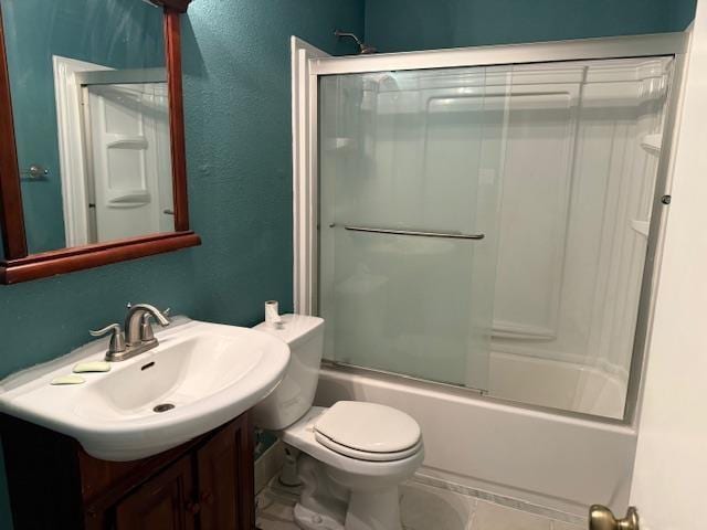 full bathroom with toilet, a textured wall, enclosed tub / shower combo, and vanity