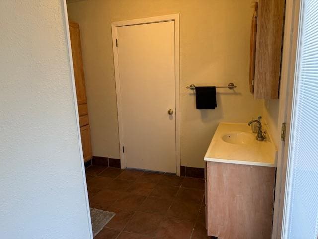 bathroom featuring tile patterned flooring, vanity, and baseboards